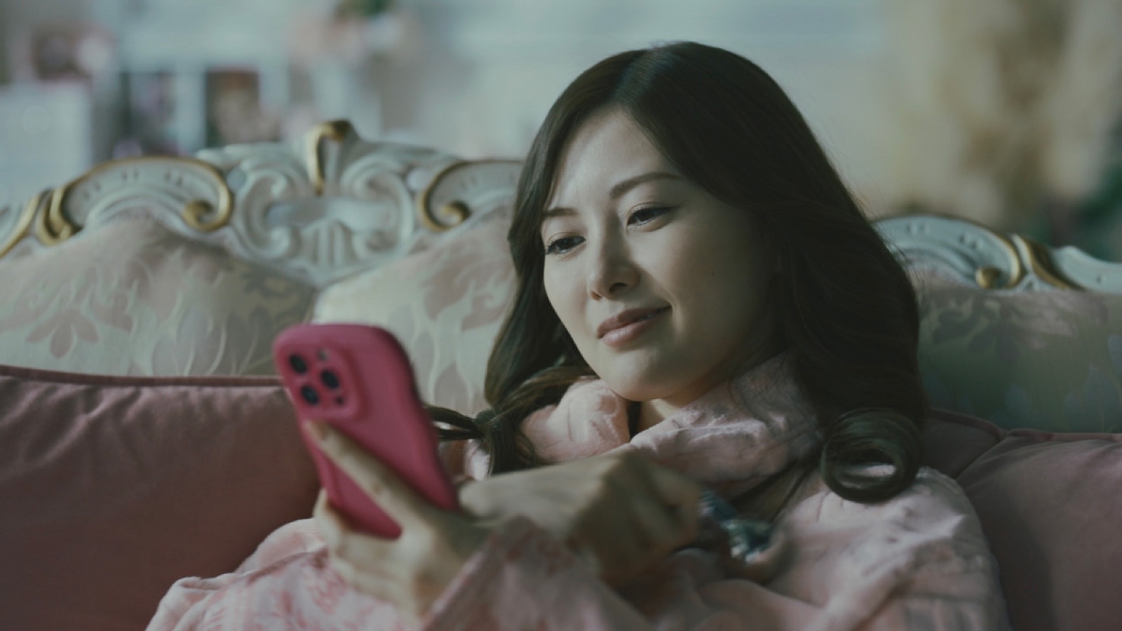 提前回家的藤崎奈津美坐在沙发上查看手机